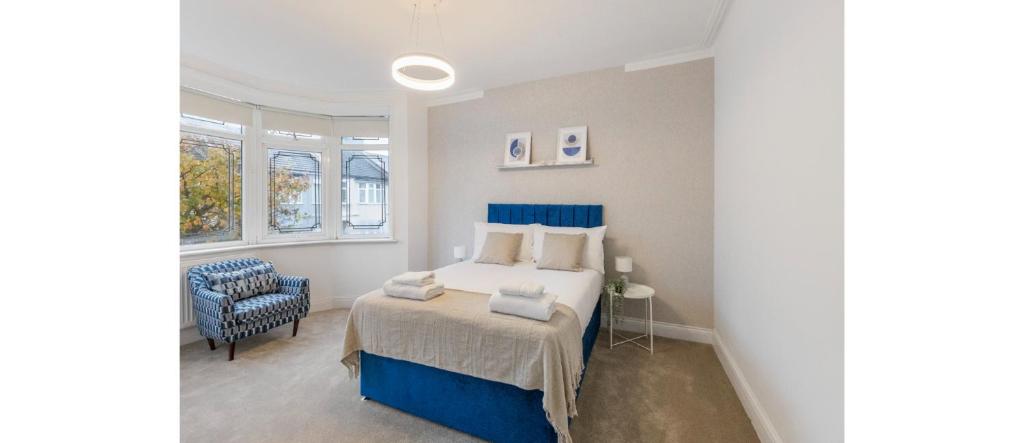 um quarto com uma cama com uma cabeceira azul em Essex Vibes: Modern, Funky, & Spacious 4-Bed House em Southend-on-Sea