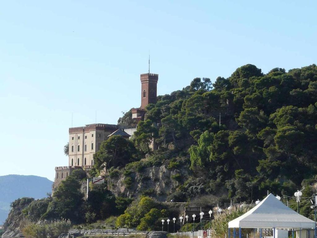zamek na szczycie wzgórza z budynkiem w obiekcie Casa Isa a 30 metri dalla spiaggia w mieście Borghetto Santo Spirito