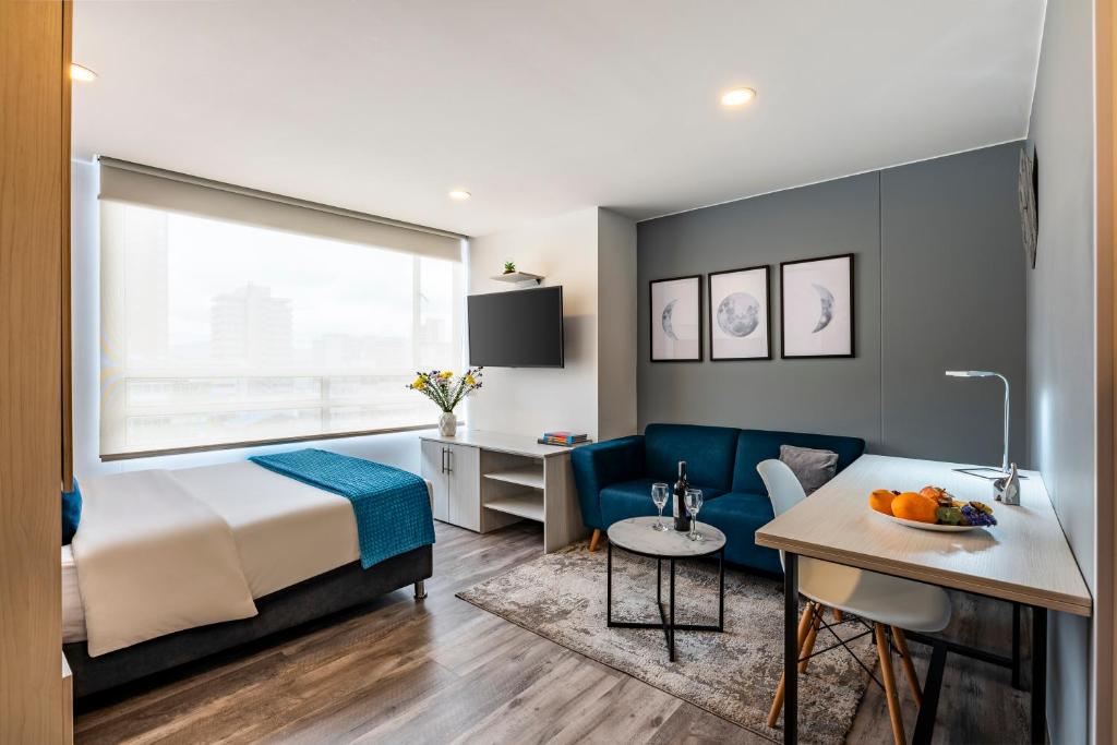 a hotel room with a bed and a desk at Torre Acqua Lofts - Downtown Bogota By Jalo in Bogotá