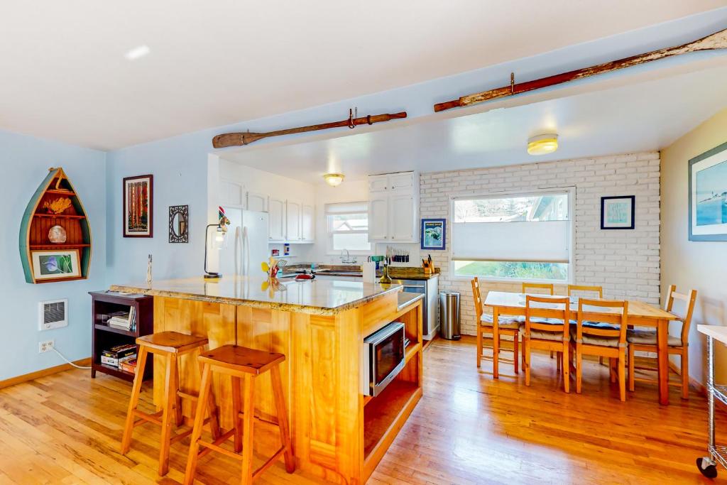 Creeksong Retreat في كريسنت سيتي: مطبخ وغرفة طعام مع طاولة وكراسي