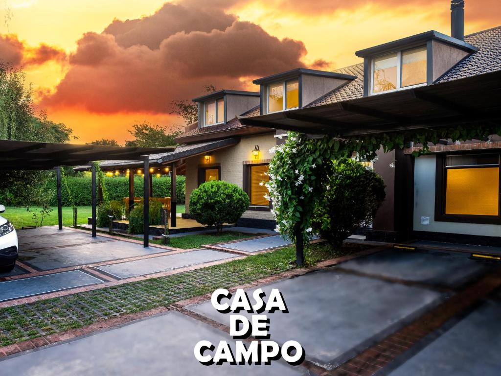 a house with a sunset in the background at Casa de Campo in La Falda