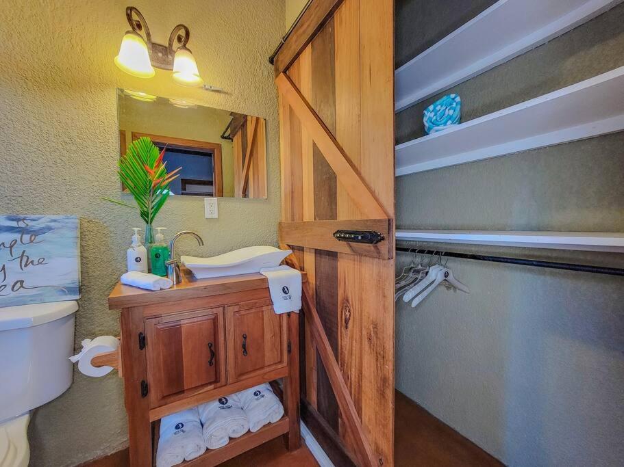 a bathroom with a sink and a toilet and a mirror at Vive Utila - Bed & Breakfast in Utila