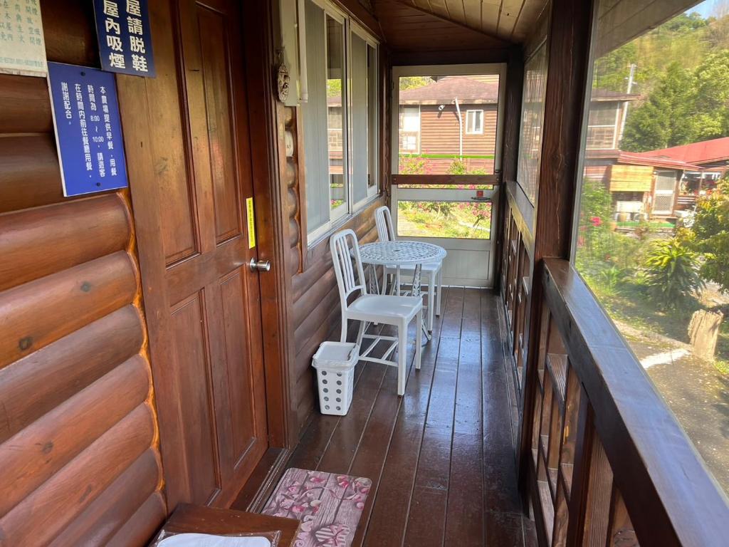 a porch of a house with two chairs and a table at Ji Ji Farm Homestay in Jiji