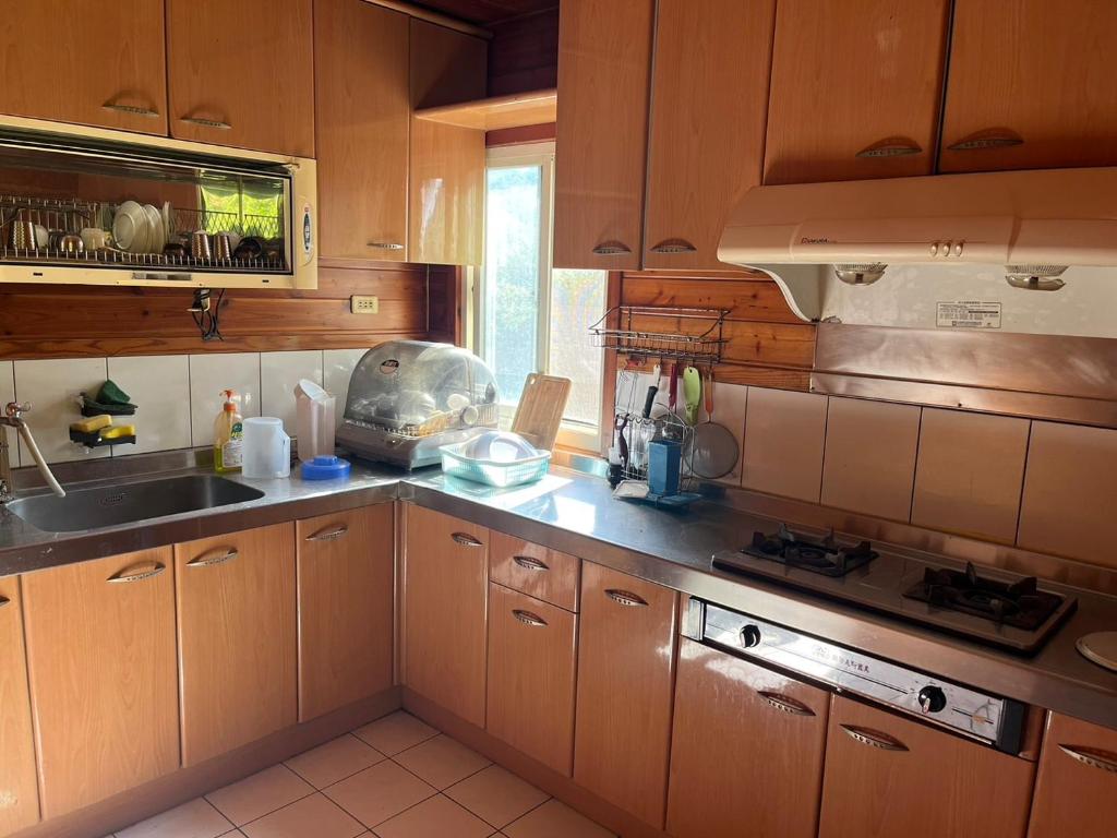a kitchen with wooden cabinets and a sink at Ji Ji Farm Homestay in Jiji