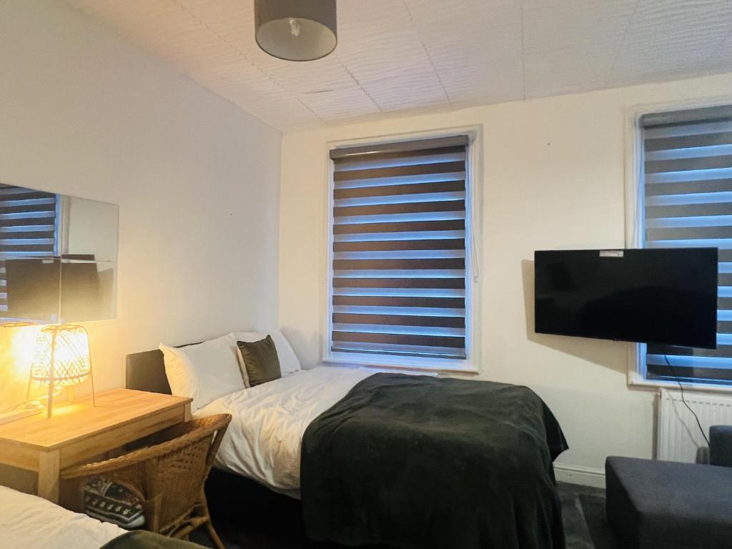 a bedroom with a bed and a flat screen tv at Impeccable 1 Bedroom Flat in Central London in London