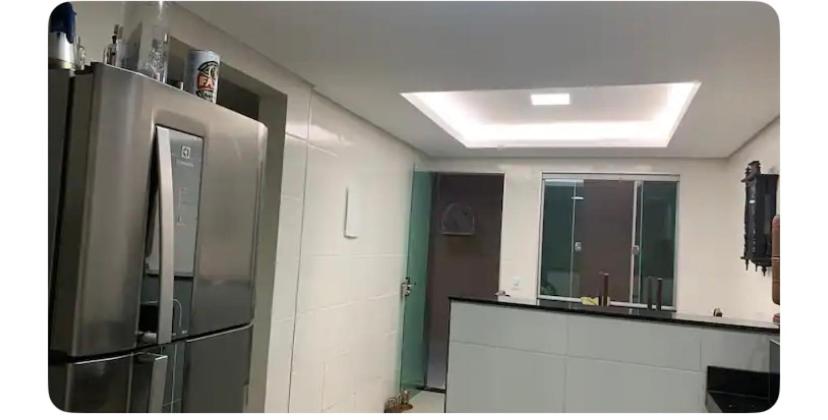 uma cozinha com um frigorífico de aço inoxidável e um espelho em TALLYS em Belo Horizonte