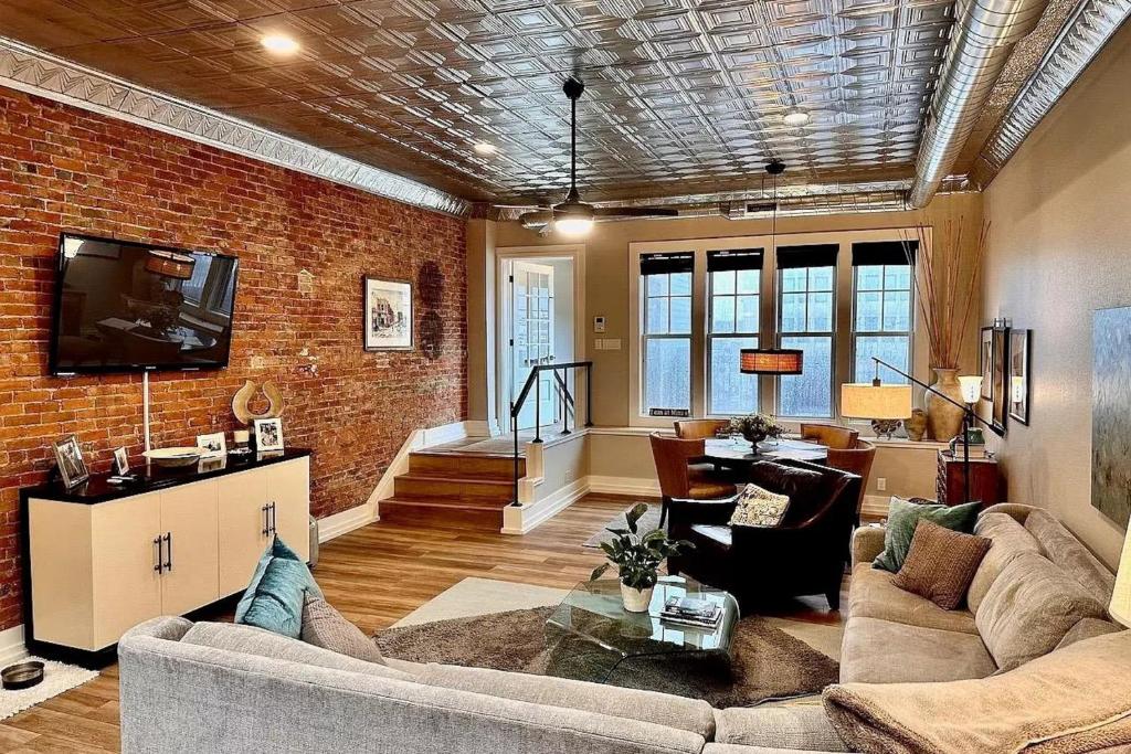 a living room with a couch and a brick wall at Downtown Delight in Muncie