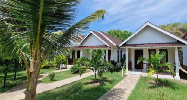 una casa con una palmera delante de ella en parida bungalow, en Gili Air