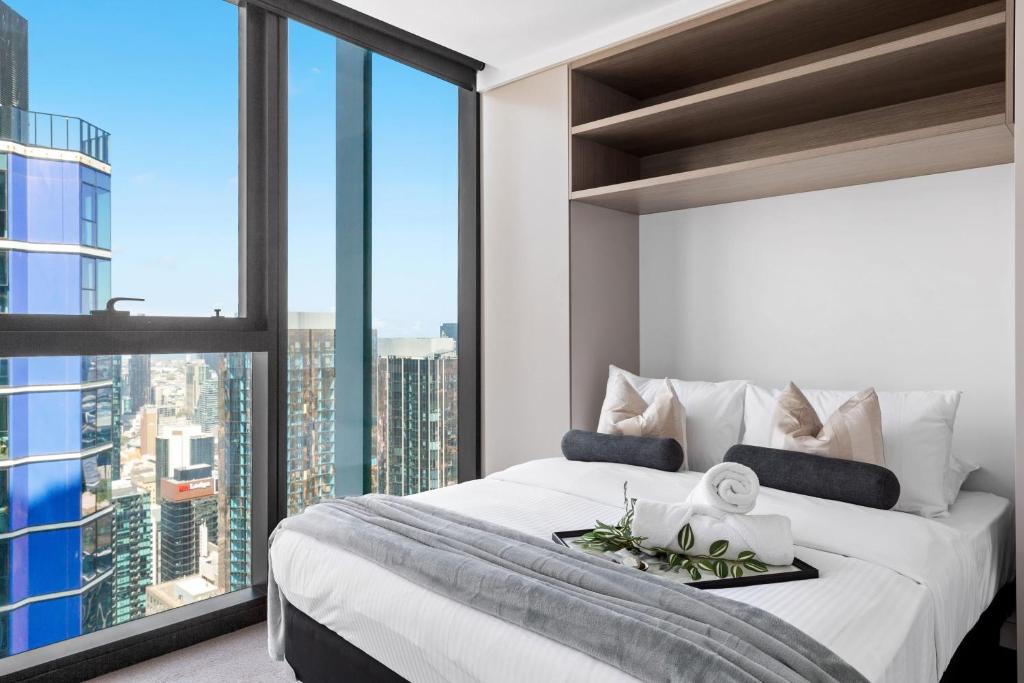 um quarto com uma cama grande e uma janela grande em A Cozy & Comfy 2BR Apt Up in the Clouds Near CBD em Melbourne