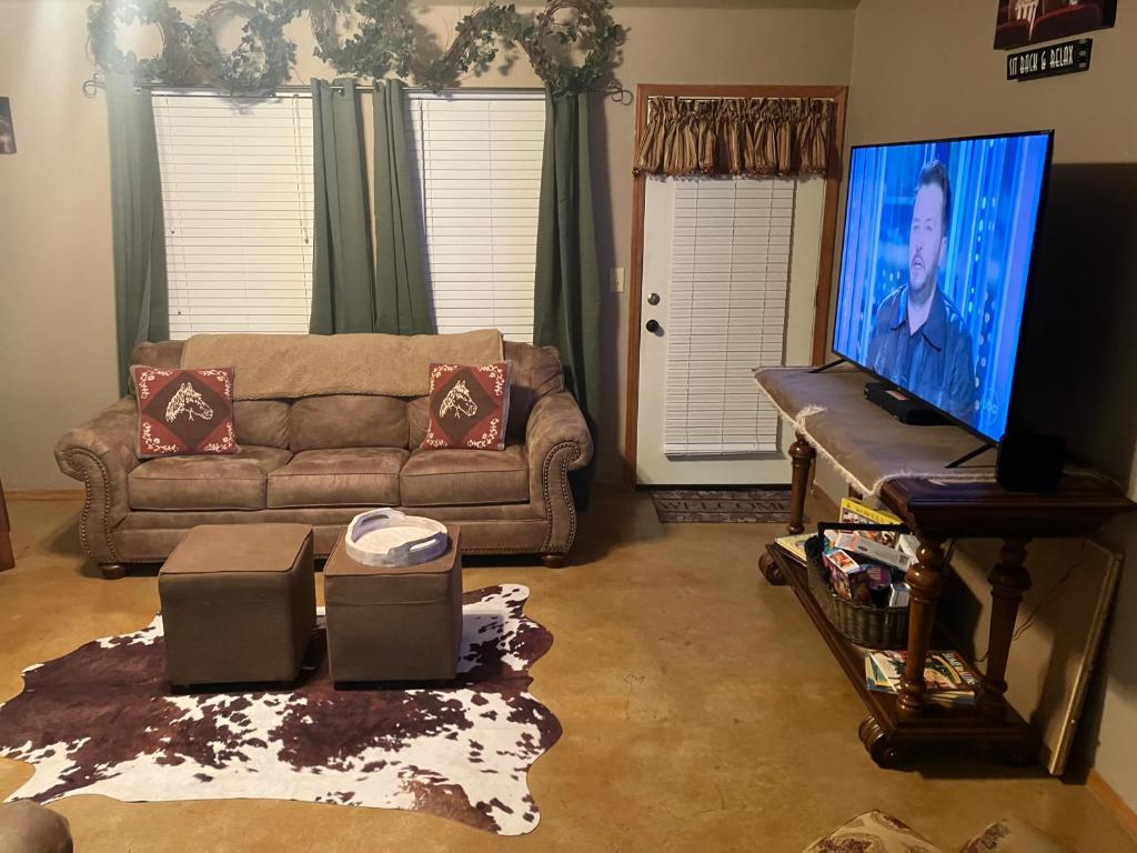 a living room with a couch and a flat screen tv at And Boots Start Knocking in Stillwater