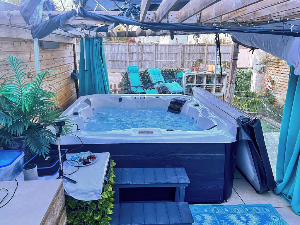 a jacuzzi tub in a backyard with a table and chairs at Upstairs Downstairs Regency Apartments in Cheltenham