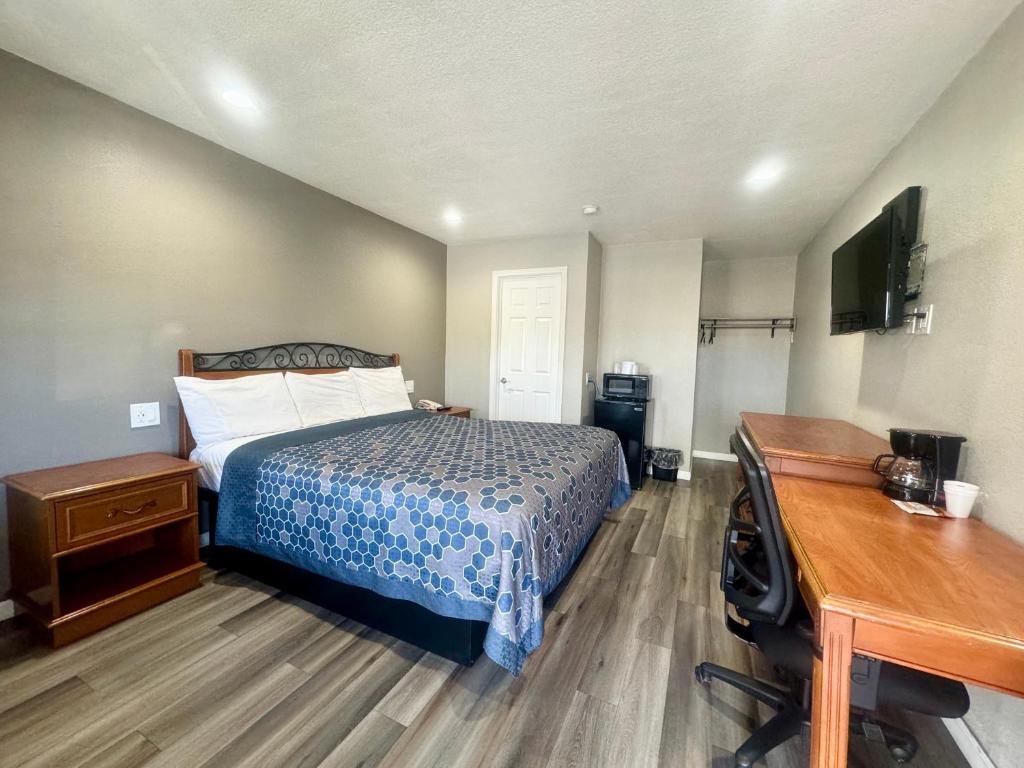 a bedroom with a bed and a desk and a desk at Villa Court Inn Oroville in Oroville