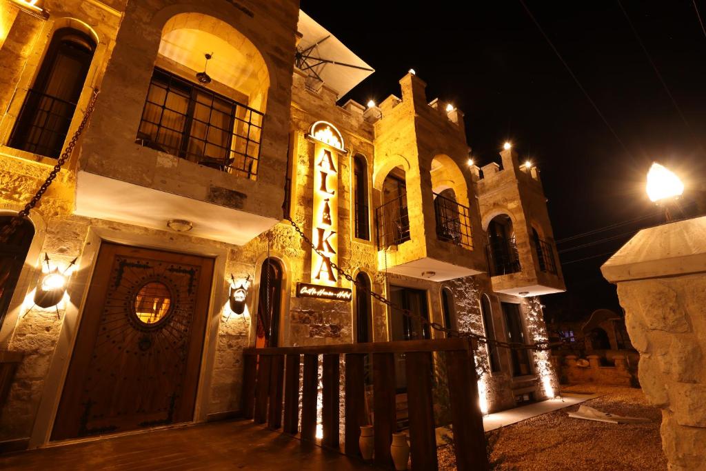 a building with a sign on it at night at Alika Castle House in Uchisar
