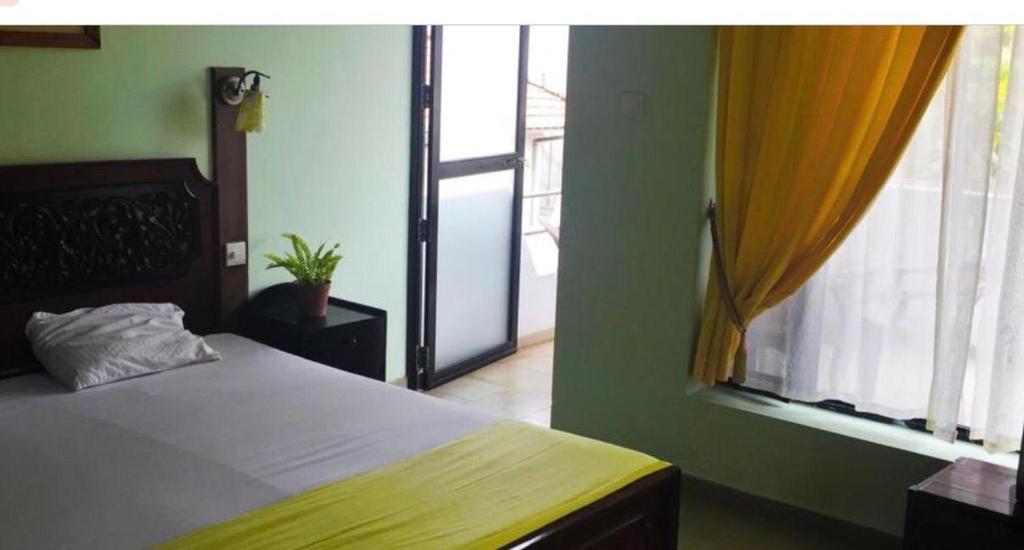 1 dormitorio con cama y ventana grande en S and P apartments, en Negombo