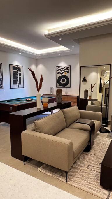 a living room with a couch and a pool table at شقة خاصة فاخرة + صالة بلياردو in Riyadh