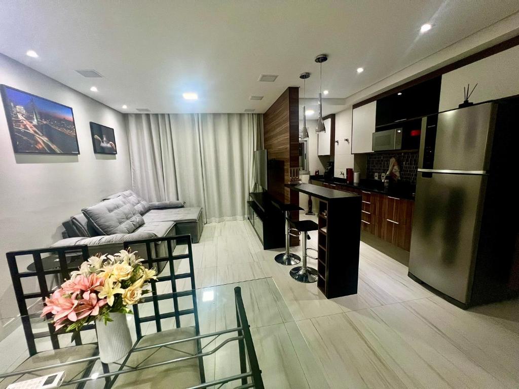 Hotel Moderno apartamento ao lado do Consulado Americano, a living room and kitchen with a couch and a table at Moderno apartamento ao lado do Consulado Americano in São Paulo