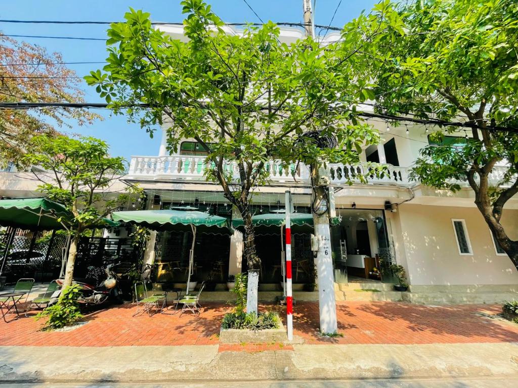 ein Gebäude mit Bäumen davor in der Unterkunft SAMI Coffee Hotel in Dong Hoi