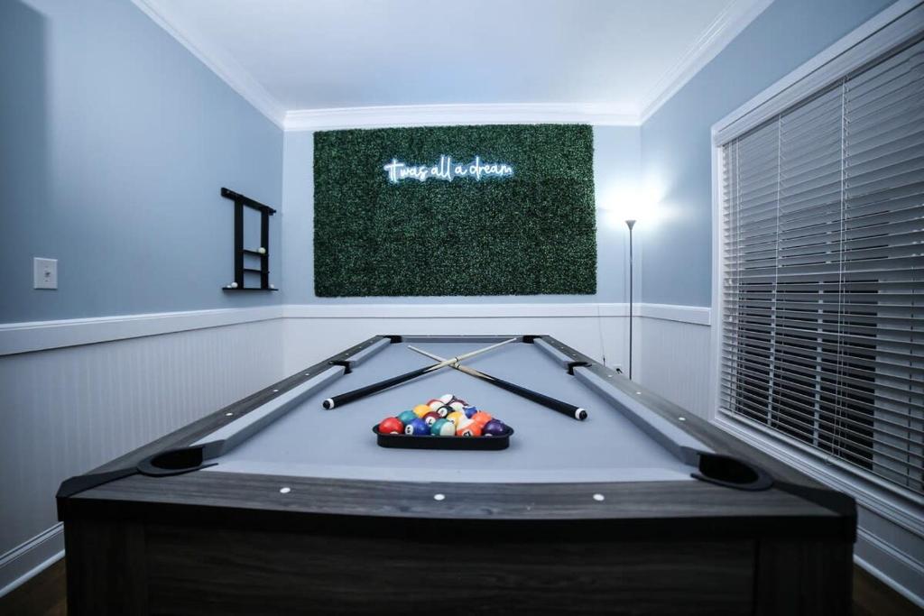 a ping pong table in a living room with a billiard at Big 5 Bdrm Private Hot Tub Pool Table Near Shops in Loganville