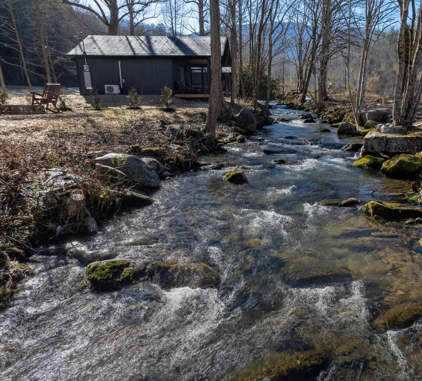 a river with rocks in front of a house at Misty Cove Cabin, Pickleball Court, Creek, WIFI, Mountain Views, No Cleaning Fee in Cosby