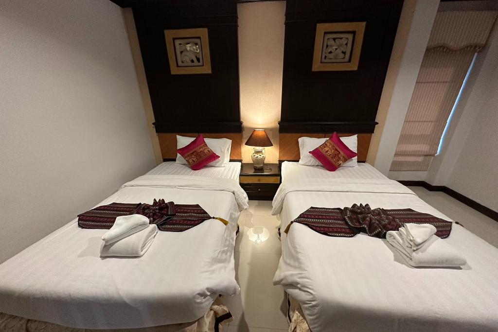 Postel nebo postele na pokoji v ubytování Chiangrai Grand Room Hotel