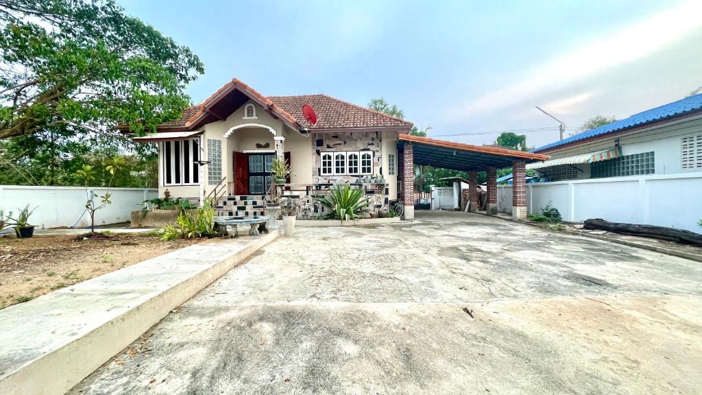 uma casa com uma grande entrada de garagem em frente em บ้านเพื่อน @อุทัยธานี em Ban Don Khwang