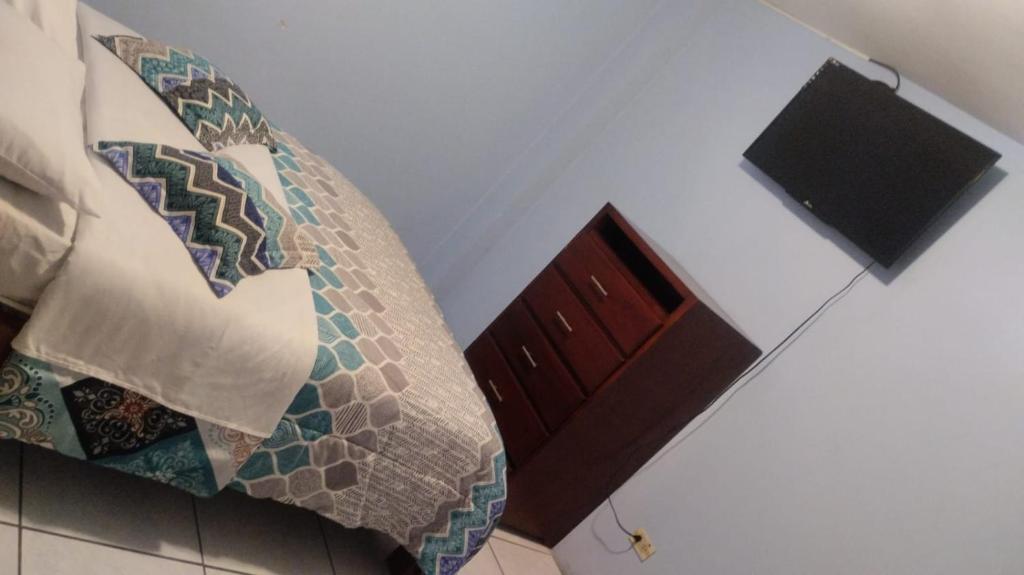 - une chambre avec un canapé, des oreillers en mosaïque et une fenêtre dans l'établissement Hostal Maria José, à Baños