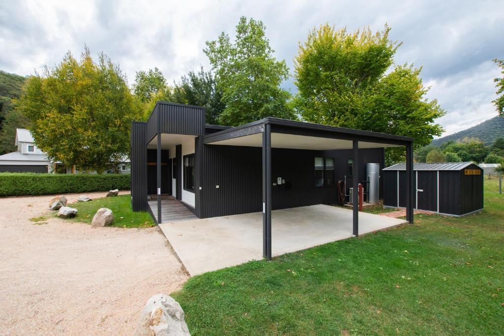una casa negra con un garaje en un patio en Telluride - wonderful disabled facilities, en Harrietville