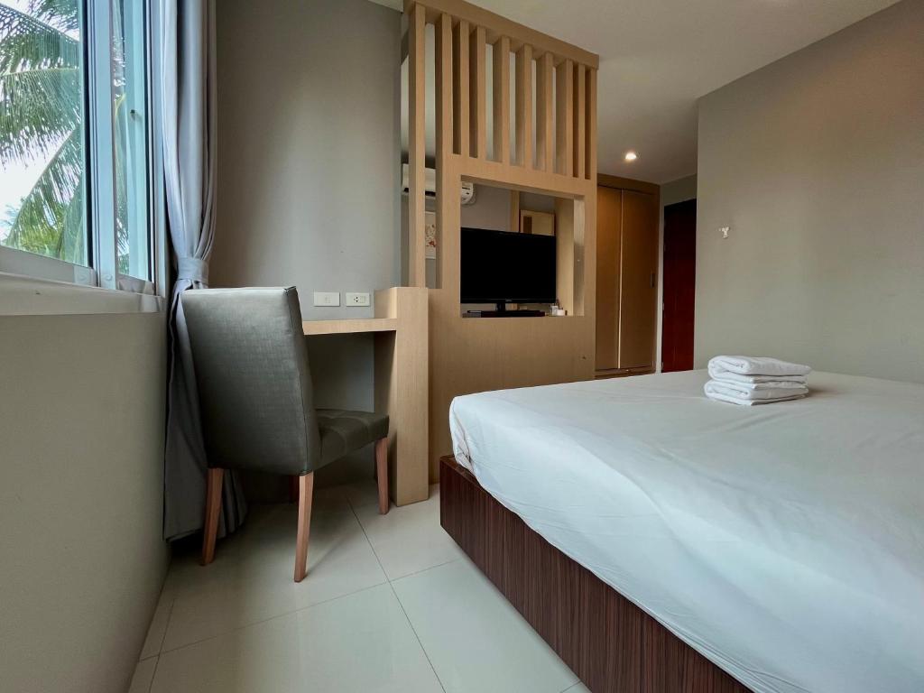 a bedroom with a bed and a desk and a chair at Hidayah Condotel,Ao-nang, Krabi in Ban Khlong Haeng