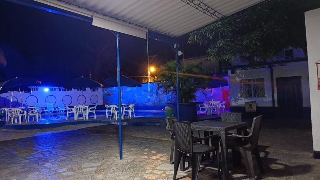 un patio con tavoli e sedie di notte di Hotel Guaipa melgar a Melgar