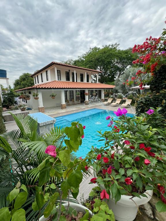 einem Pool mit Blumen und Pflanzen vor einem Gebäude in der Unterkunft Casa Isidra in Rivera