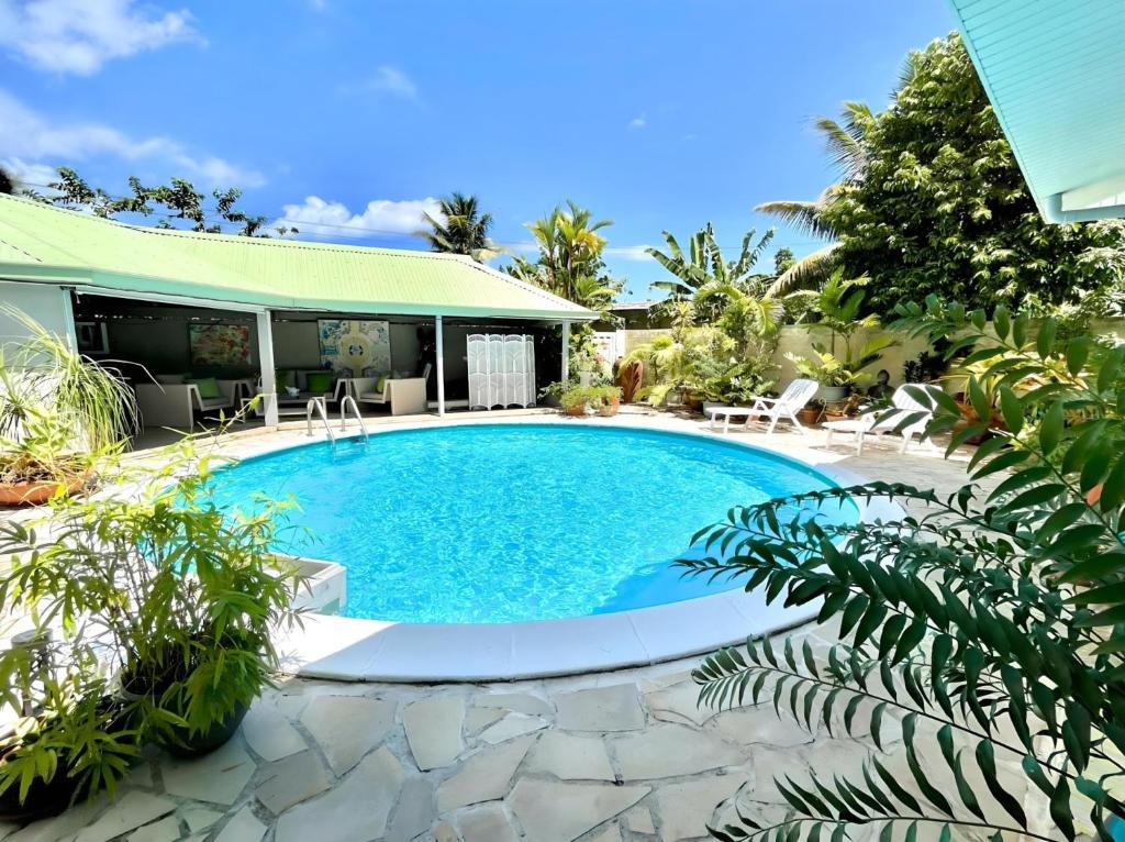 a swimming pool in the backyard of a house at Tiaki Guesthouse - Cozy Modern Studio - 5min drive from the beach and Punaauia center in Punaauia