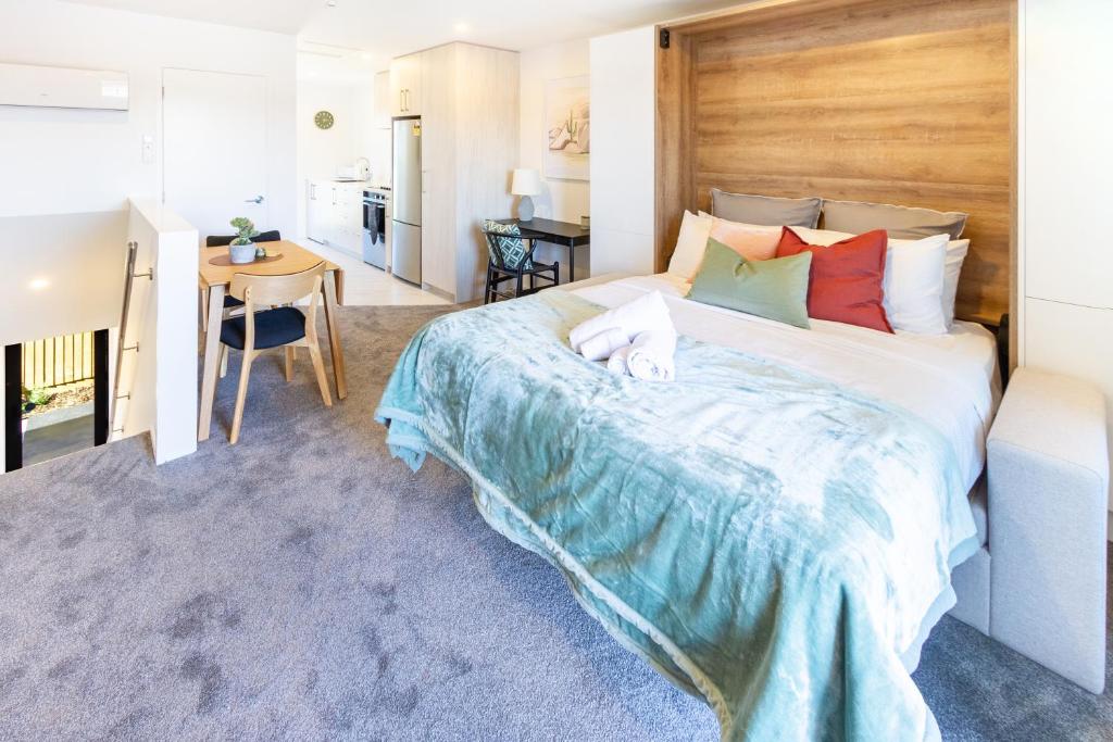 a bedroom with a large bed with a wooden headboard at City Living: Upper Studio Haven on Wilmer in Christchurch