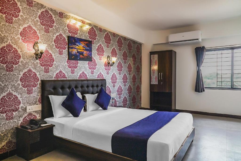 a bedroom with a large bed with blue pillows at Kharadi in Kharadi