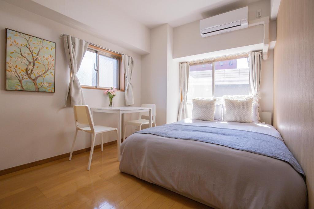 1 dormitorio con cama, escritorio y ventana en walk to JR Shibuya sta.-QoE2, en Tokio