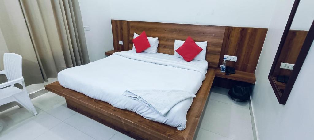 a bed with red pillows in a room at The Grace Residency in Gurgaon