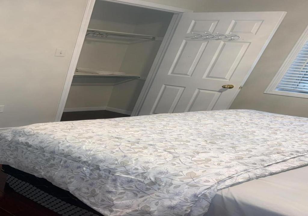 - une chambre avec un lit et une porte blanche dans l'établissement Bright Queen Room, à Brampton
