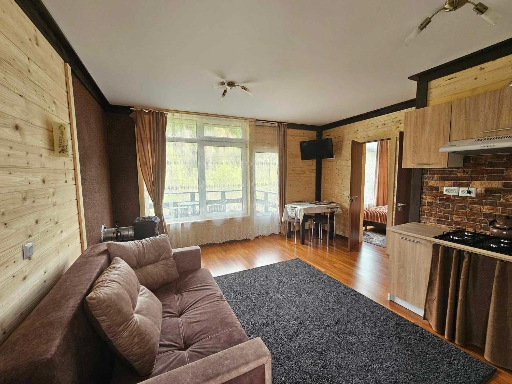 een grote woonkamer met een bank en een keuken bij Симфонія біля річки Чан in Skole