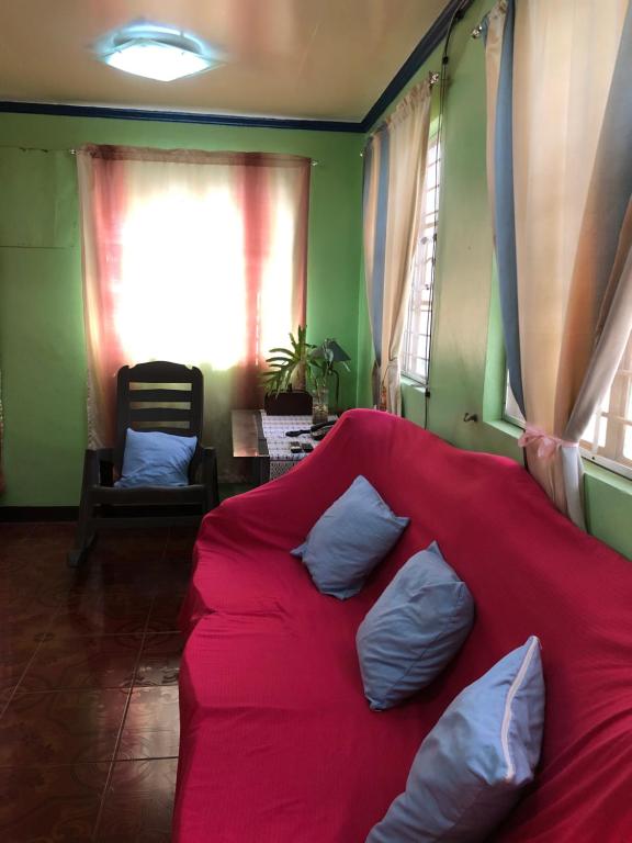 un divano rosso con tre cuscini sopra in una stanza di Quiet Garden Home a Molino