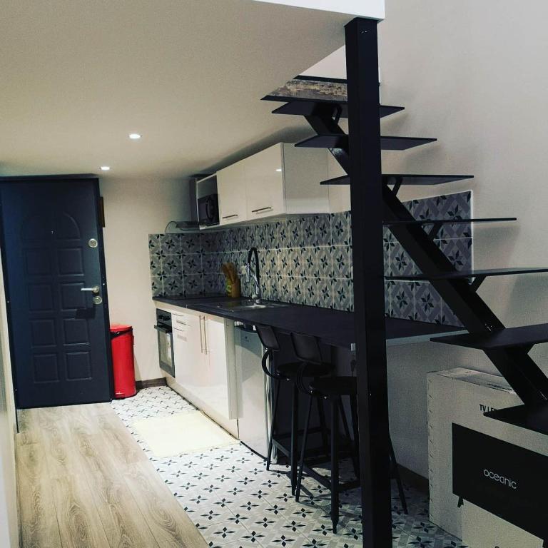 une cuisine avec un comptoir et un bar avec des tabourets dans l'établissement Les Lofts De Livry: Appartement 2, à Livry-Gargan