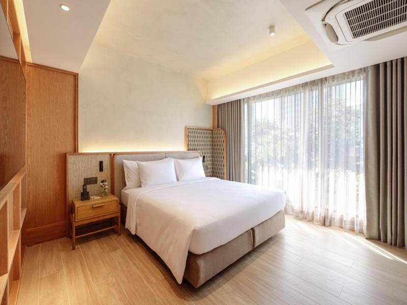 1 dormitorio con cama blanca y ventana grande en Ad Lib Hotel Bangkok, en Bangkok