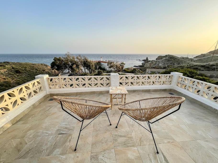 2 stoelen en een tafel op een balkon met uitzicht op de oceaan bij Casa Fiorella en Cabo de Gata. in Níjar