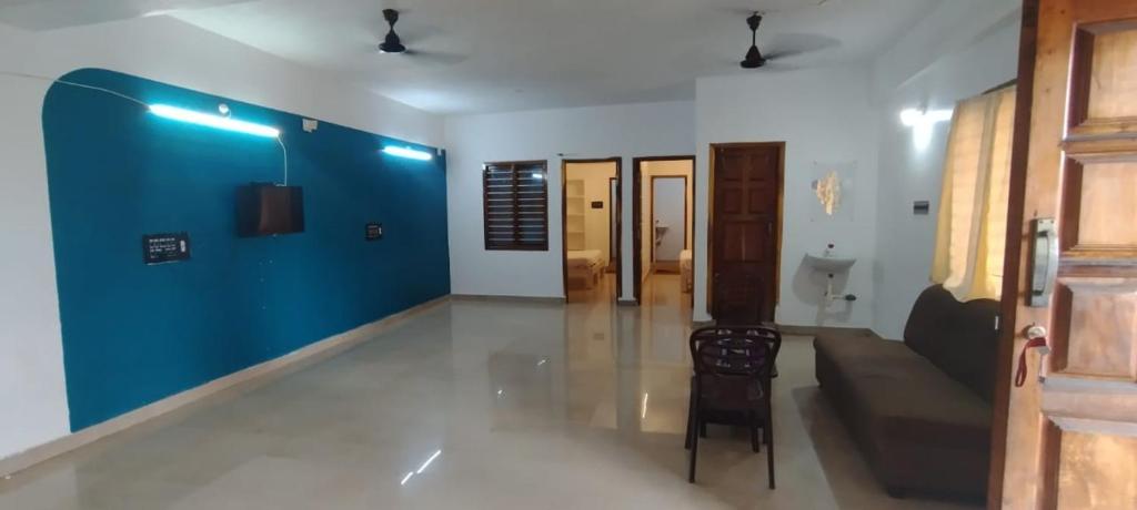 a living room with a couch and a blue wall at cg residency in Pondicherry