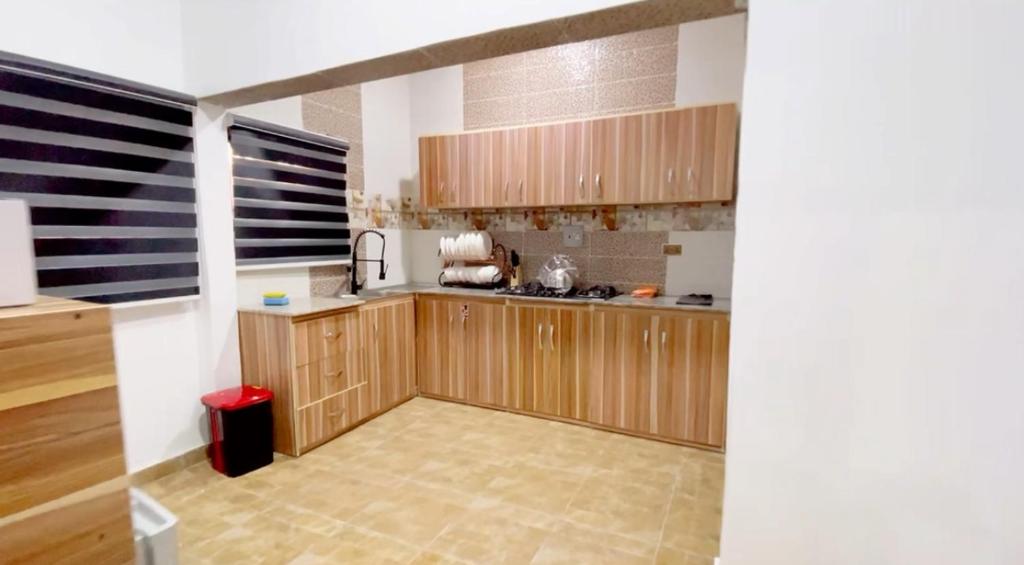 cocina con armarios de madera y encimera en CEO HOMES AND APARTMENT, en Warri