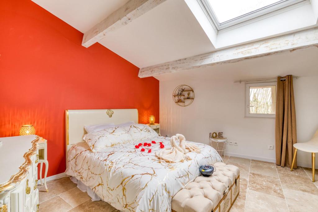 een slaapkamer met een oranje muur en een bed bij Le love baroque in Lézignan-la-Cèbe