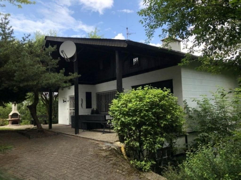 維林根的住宿－Chalet BERGgrün Willingen，白色和黑色的房子,前面有长凳