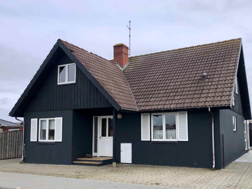 una casa negra con techo marrón en Charming Townhouse With Plenty Of Space, en Thyborøn