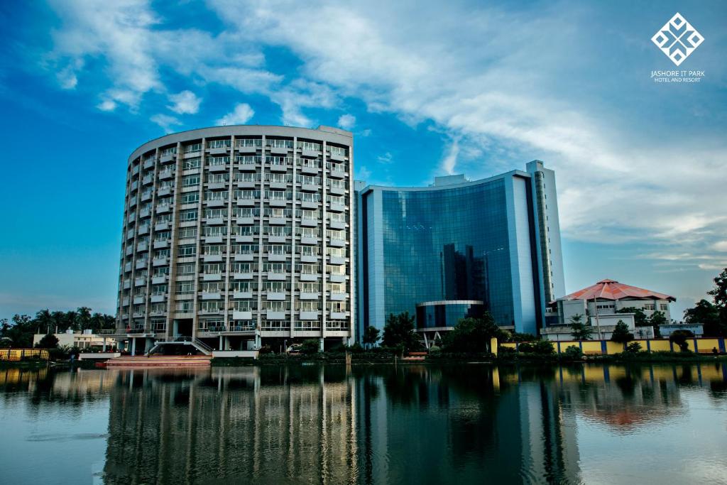 a large building next to a body of water at Jashore IT Park Hotel and Resort in Jessore