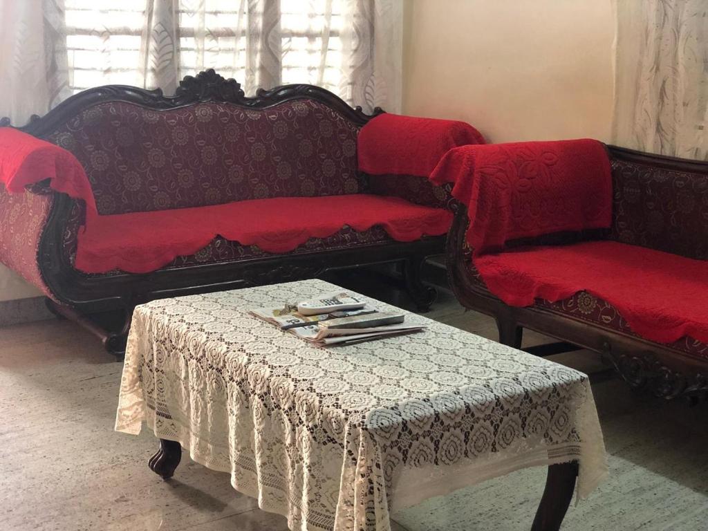a living room with two couches and a table at Mahagiri Nest in Mysore