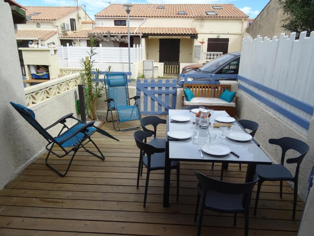 un patio avec une table et des chaises sur un balcon dans l'établissement Maison près des plages, à Port-la-Nouvelle