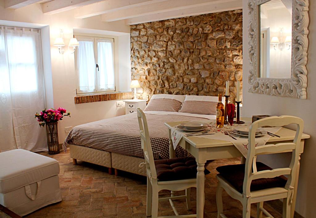sypialnia z łóżkiem, stołem i krzesłami w obiekcie Albergo Diffuso Polcenigo Ca' Bianca w mieście Polcenigo